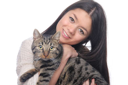 Beautiful asian teen woman with her pet in front of a white backgroundの写真素材