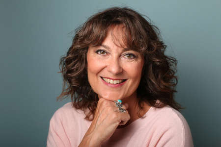 Portrait of a beautiful happy woman in front of a colored backgroundの写真素材