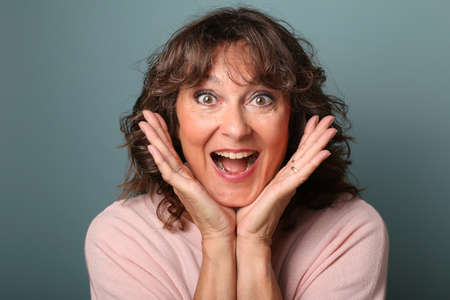 Portrait of a beautiful happy woman in front of a colored backgroundの写真素材