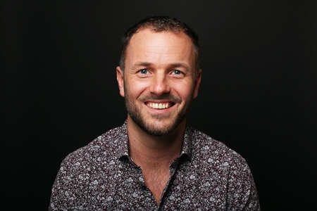 Portrait of a beautiful happy man in front of a colored backgroundの写真素材