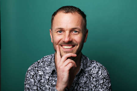Portrait of a beautiful happy man in front of a colored backgroundの写真素材