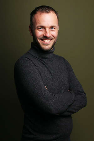 Portrait of a beautiful happy man in front of a colored backgroundの写真素材