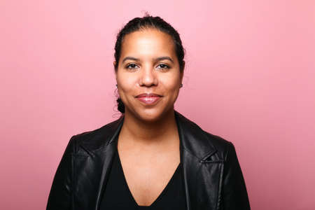 Portrait of a beautiful happy woman in front of a colored backgroundの写真素材