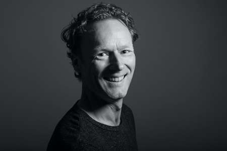 Portrait of a beautiful happy man in front of a colored backgroundの写真素材