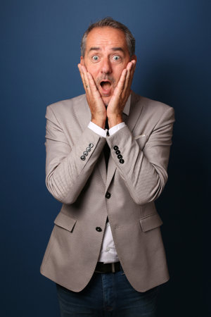 Portrait of a beautiful happy man in front of a colored backgroundの写真素材