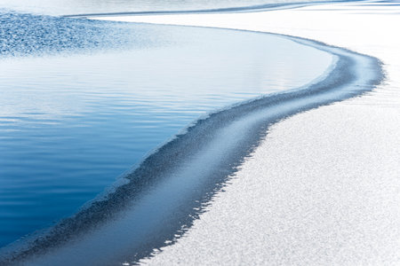 Frozen lake water with ice and snow.の写真素材