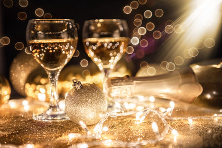Champagne glasses isolated on golden background. festive christmas background with ornaments.の写真素材