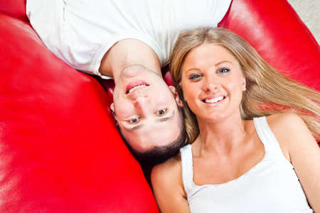 Happy couple lying on bed and smilingの写真素材