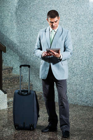 Businessman checking flight timetable on tabletの写真素材