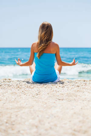Woman meditating on beachの写真素材