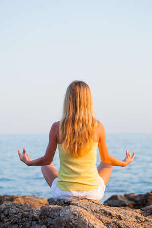 Woman meditating on seashoreの写真素材