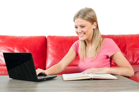 Woman reading book and using laptopの写真素材