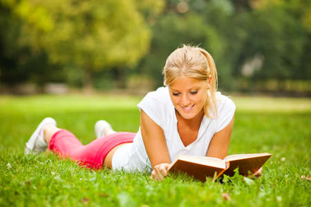 Woman reading a book in parkの写真素材