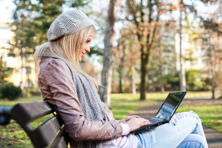 Woman using laptop in parkの写真素材