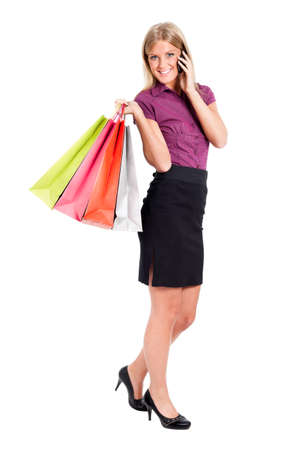 Woman with shopping bags talking on phone, isolated on whiteの写真素材