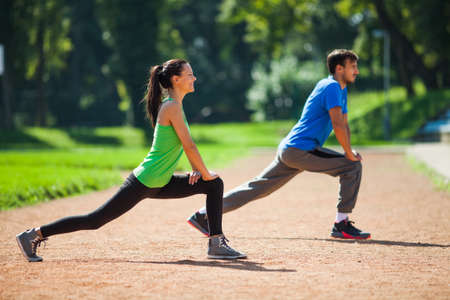 Young couple stretching bodies, warming up for joggingの写真素材
