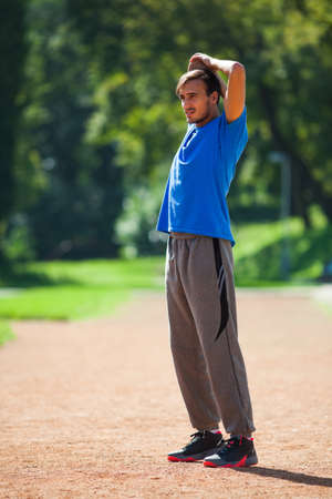 Young man stretching body, warming up for joggingの写真素材