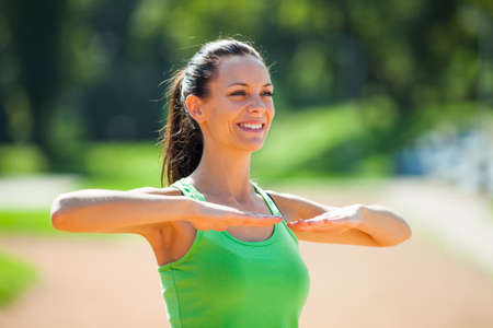 Young woman stretching body, warming up for joggingの写真素材