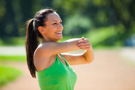 Young woman stretching body, warming up for joggingの写真素材