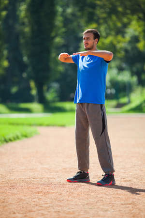 Young man stretching body, warming up for joggingの写真素材