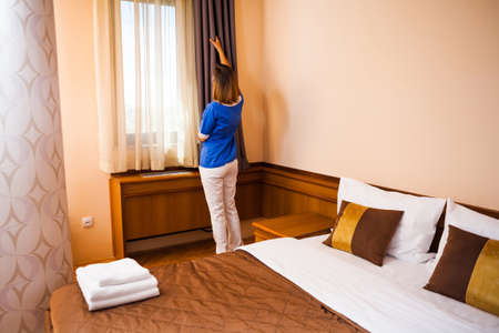 Hotel maid fixing the curtainの写真素材
