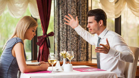 Young couple is arguing in restaurantの写真素材