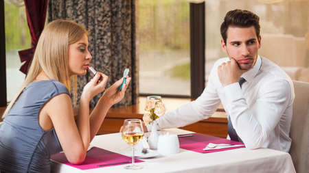 Young couple is getting bored and on first dateの写真素材