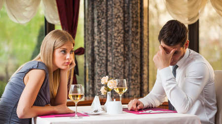 Young couple is getting bored on first dateの写真素材