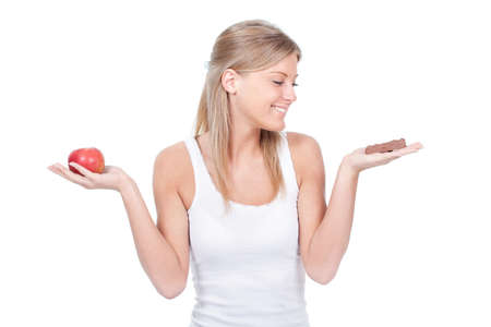 Woman holding apple and candy, fruit or candy dilemmaの写真素材