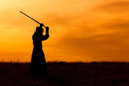 Silhouette of kendo fighter with shinaiの写真素材