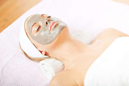 Young woman with clay skin mask on her faceの写真素材