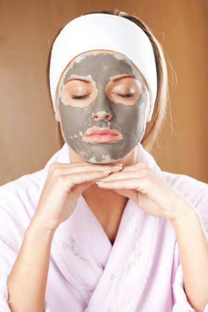 Young woman with clay skin mask on her faceの写真素材