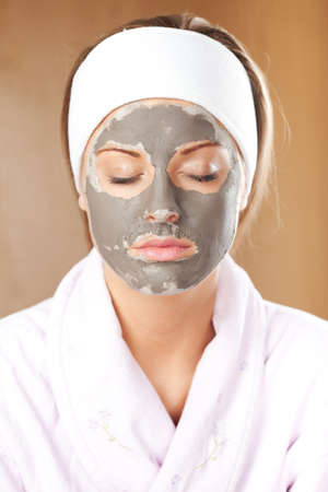 Young woman with clay skin mask on her faceの写真素材