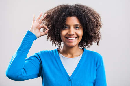 Young woman smiling and showing OK signの写真素材