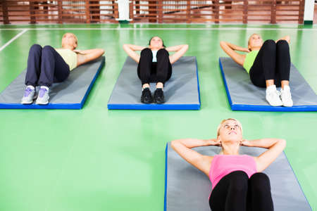 Women exercising in gym with fitness instructorの写真素材