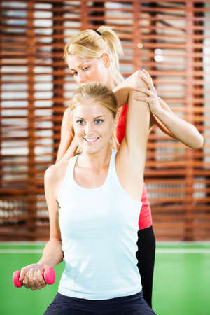 Young woman exercising in gym, using weightsの写真素材