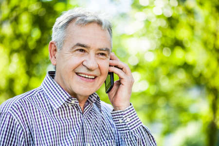Portrait of happy senior man talking on the phoneの写真素材