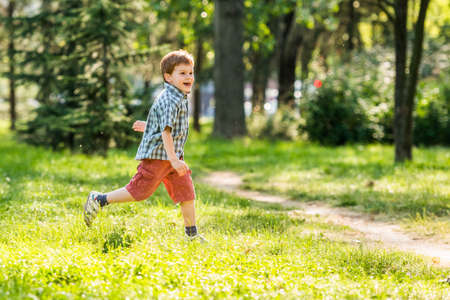 Happy boy running in parkの写真素材