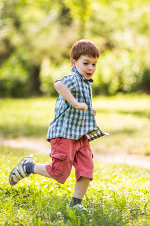 Happy boy running in parkの写真素材