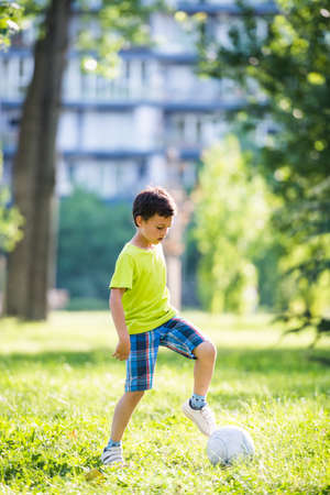 Boy playing soccer in parkの写真素材
