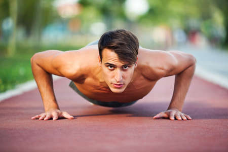 Young man exercising outdoor, doing push-upsの写真素材