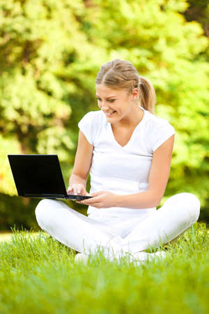 Woman using laptop in parkの写真素材