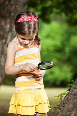 Little girl exploring nature with loupeの写真素材