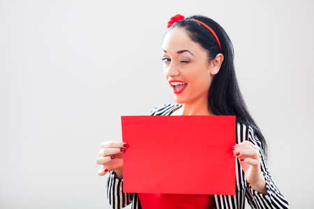 Woman holding red paper with blank space for text messageの写真素材