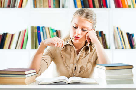 Young woman learning in libraryの写真素材