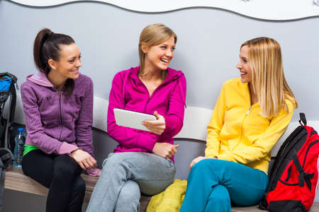 Happy girls in locker room after fitness trainingの写真素材