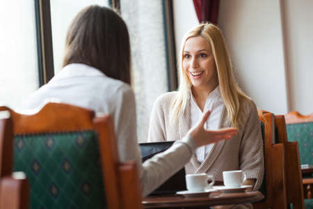 Two women talking in a cafeの写真素材