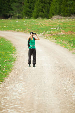 Hiker looking through binocularsの写真素材