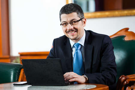 Happy businessman in his officeの写真素材