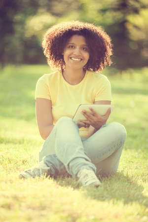 Young woman using ditiagl tablet in parkの写真素材